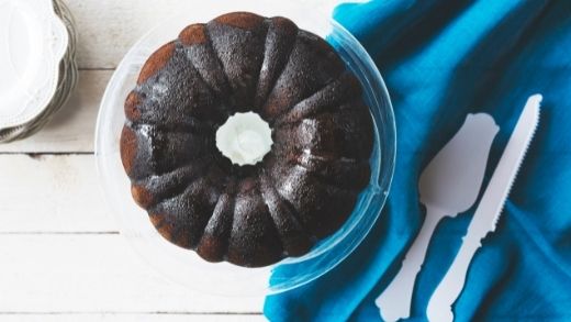 Black cocoa bundt cake on top of blue tablecloth