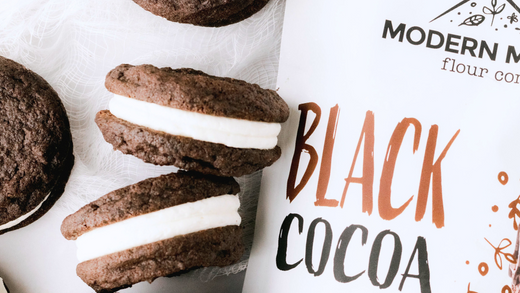 Homemade chocolate sandwich cookies next to a pouch of Modern Mountain Black Cocoa