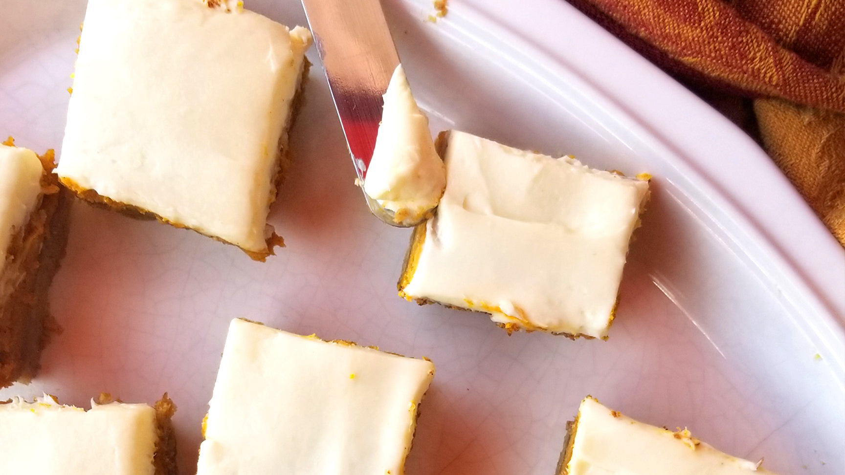 A knife frosting low-carb pumpkin pie bars
