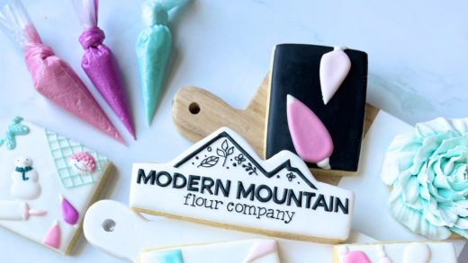 Various piping bags of icing and cookies made with Modern Mountain Meringue Powder
