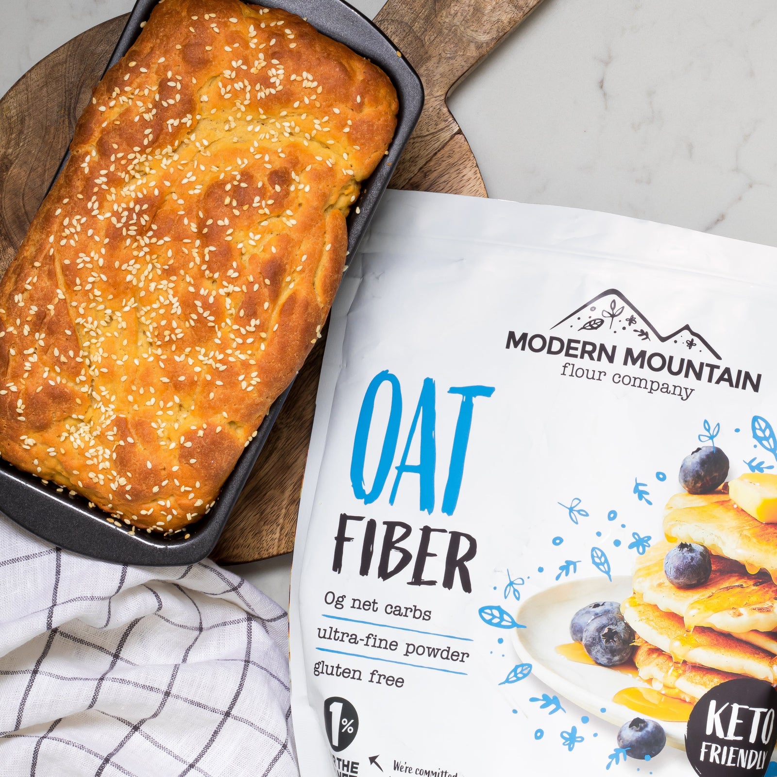 Modern Mountain Oat Fiber pouch beside a fresh-baked low-carb loaf