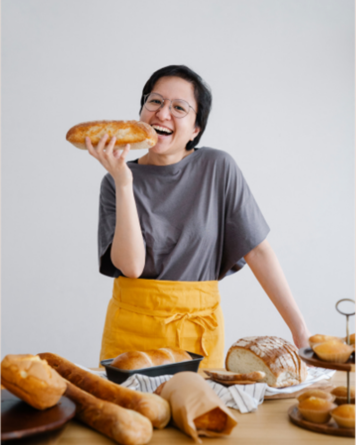 Baker dusting a cake with sugar